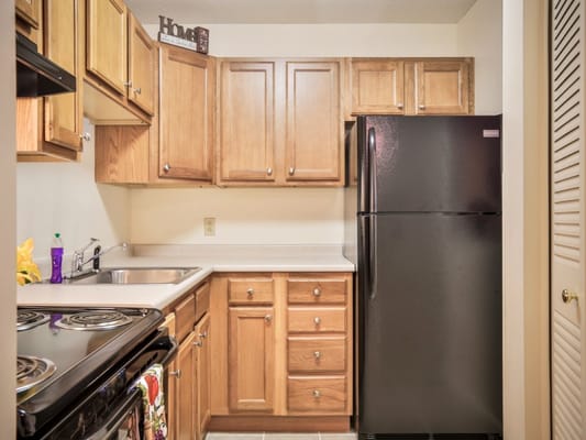 Well-lit kitchen area with wooden cabinets and appliances
