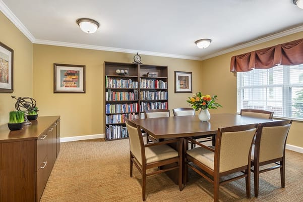 Bright common area with a table and bookshelves