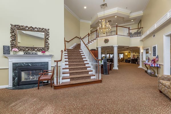 Spacious lobby with staircase and fireplace