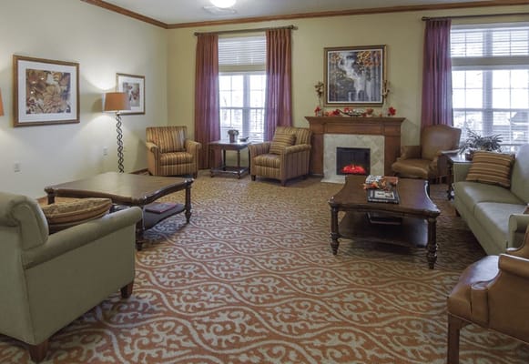 A cozy common area with armchairs and a fireplace