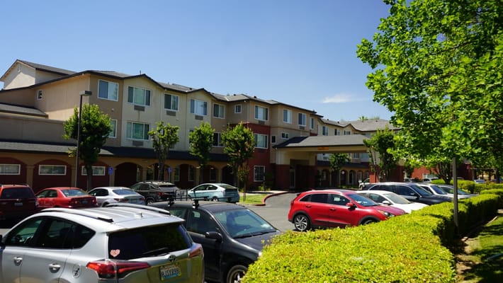 Exterior view of a senior living facility with parking area