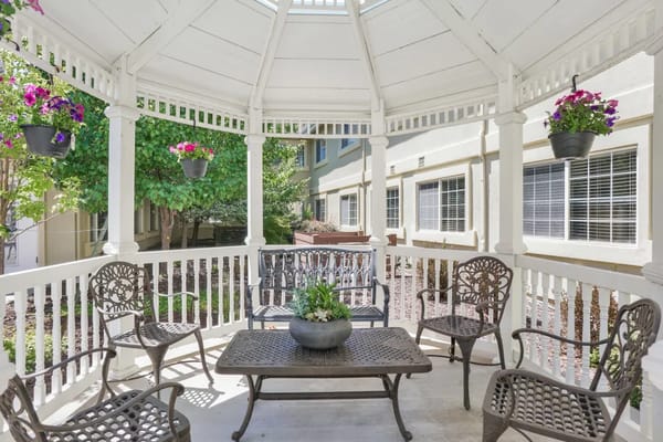 Outdoor gazebo with seating and hanging flowers
