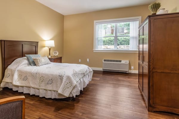 Comfortable bedroom with a bed, lamp, and wooden furniture