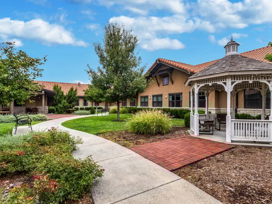 A landscaped garden with a winding pathway and gazebo at Chisholm Place.