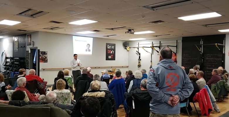 Residents participating in a fitness presentation in a common area