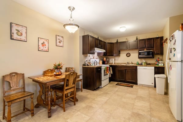 A kitchen area with dining table and appliances