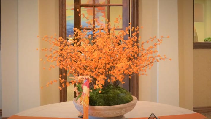 Colorful orange flower arrangement in a decorative pot