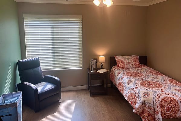 Cozy bedroom with a bed, chair, and window.