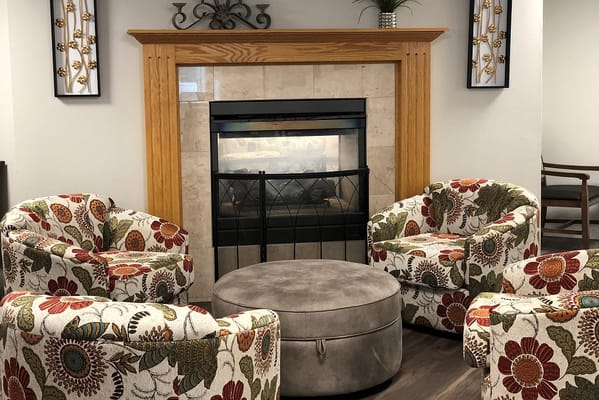 Lounge with floral chairs and a fireplace