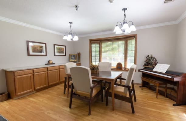 Bright dining area with a large table and piano