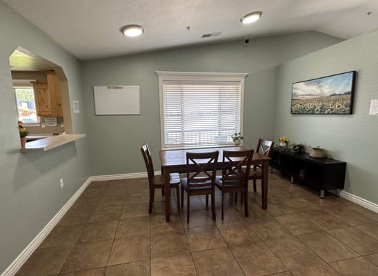 A common area with table and chairs in a bright room