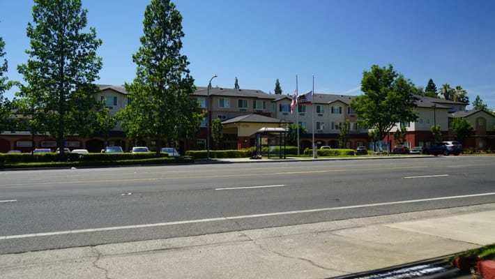 Exterior view of a senior living facility with trees