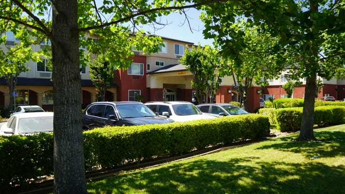 Front view of a senior living facility with landscaped garden