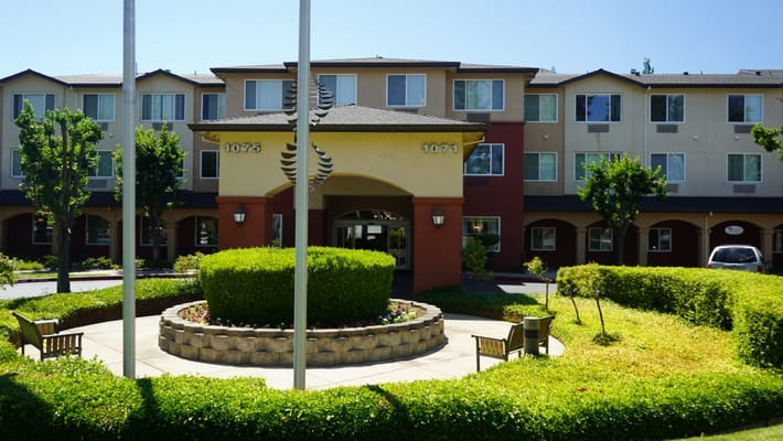 Exterior view of a senior living facility with landscaped gardens