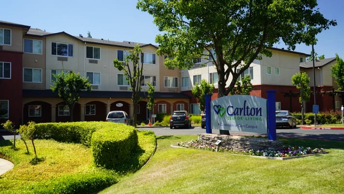 Exterior view of Carlton Senior Living with landscaped lawn