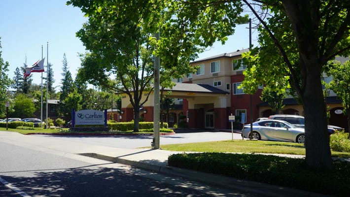Exterior view of a senior living facility surrounded by greenery