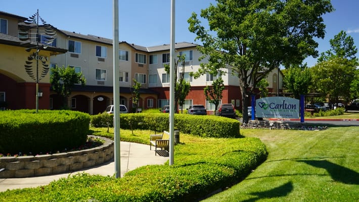 Exterior view of a senior living facility with landscaped gardens