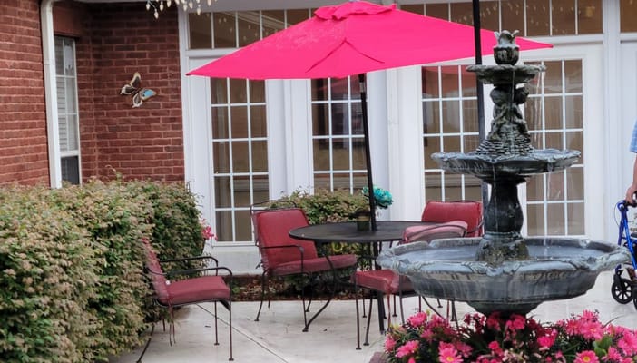 Outdoor seating area with a fountain and colorful umbrella