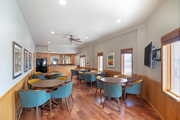 Bright common area with tables and chairs in Derian Lodge
