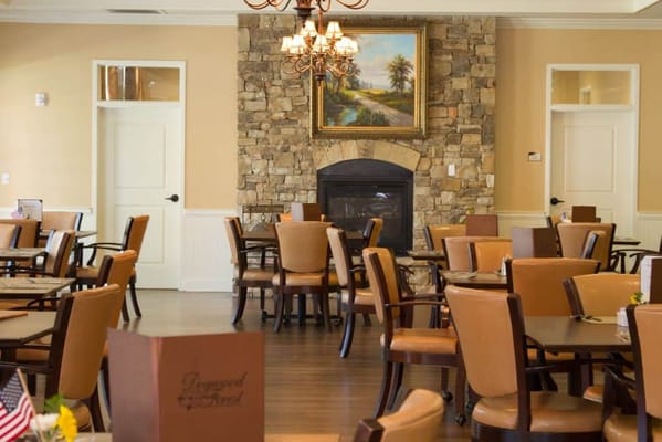 Cozy dining area with wooden tables and a stone fireplace