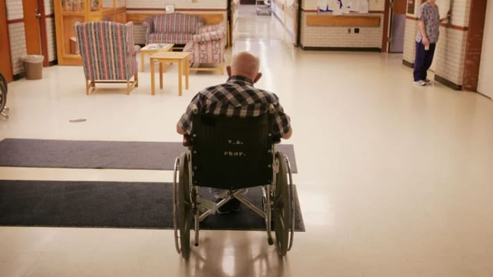 Resident in a wheelchair in a hallway