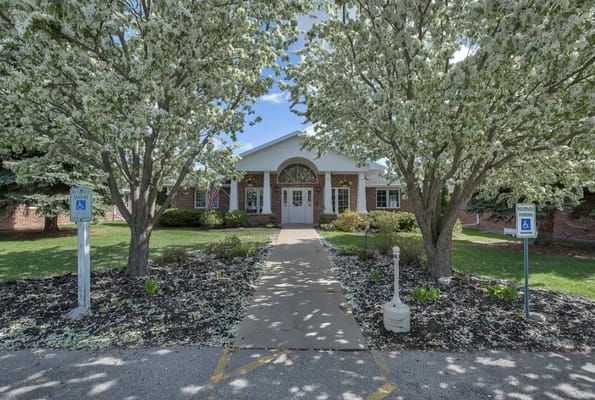 Entrance of a senior living facility surrounded by trees