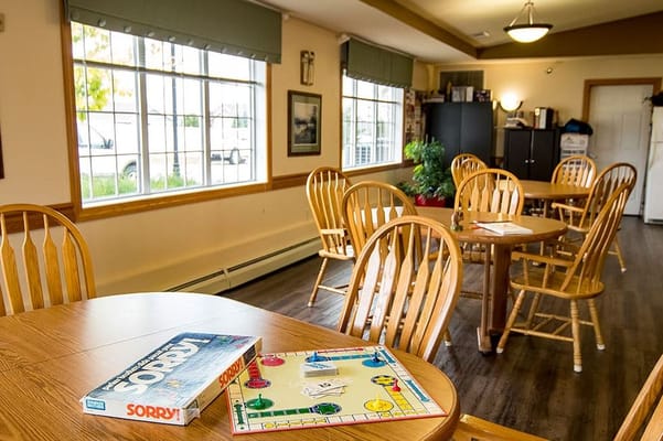 Spacious common area with wooden tables and games at Edgewood Vista & Village.