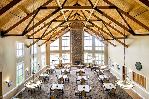 Spacious dining room with high ceiling and large windows
