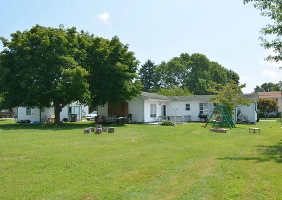 Outdoor space with green grass and trees near the facility