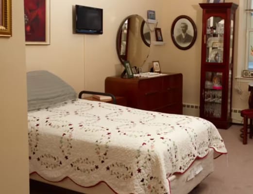 A cozy bedroom with a quilted bed and vintage furniture.