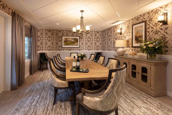 Spacious dining room with a large wooden table and elegant decor.