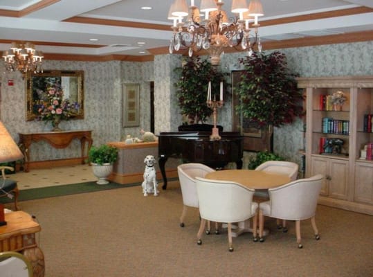 A cozy common area with a piano and plants