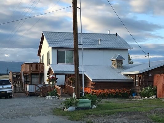Exterior view of a senior care facility with garden and porch
