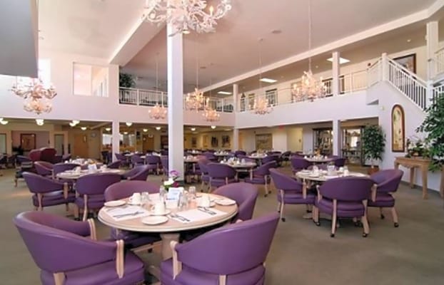 Spacious dining area with purple chairs and elegant chandeliers