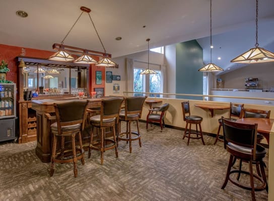 Cozy bar area with wooden stools and pendant lighting