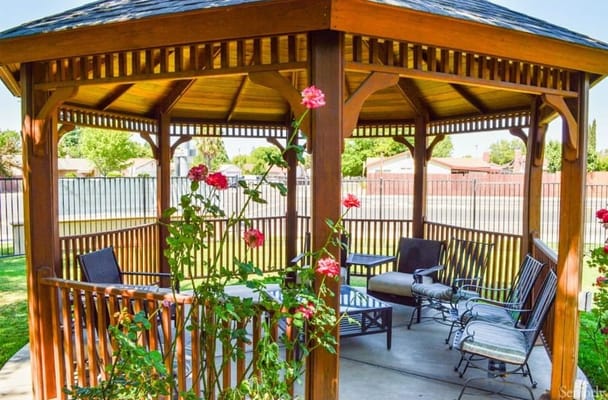 Wooden gazebo surrounded by flowers and seating area