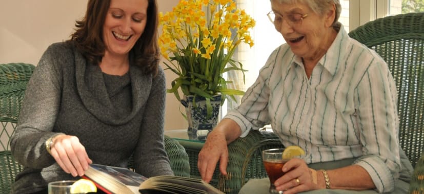 Staff member and resident looking at a photo album together