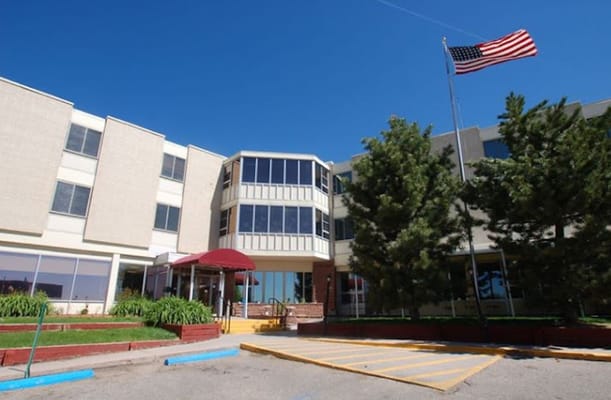 Exterior view of Granite Rehabilitation and Wellness facility with a flag and trees.