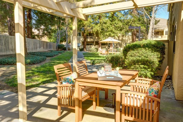 Outdoor patio with wooden furniture and greenery