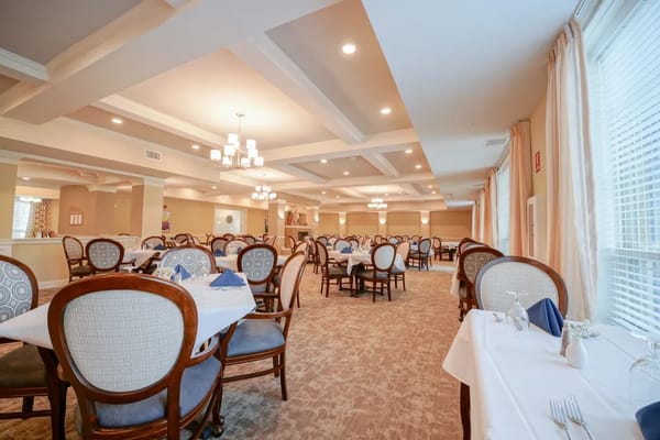 Bright dining room with well-set tables and chairs.
