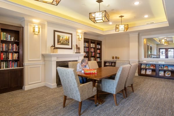 Resident playing a game at a table in the common area