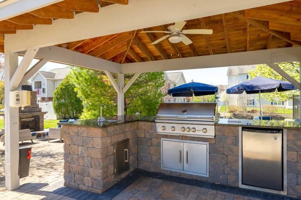Outdoor grilling area with seating and umbrellas