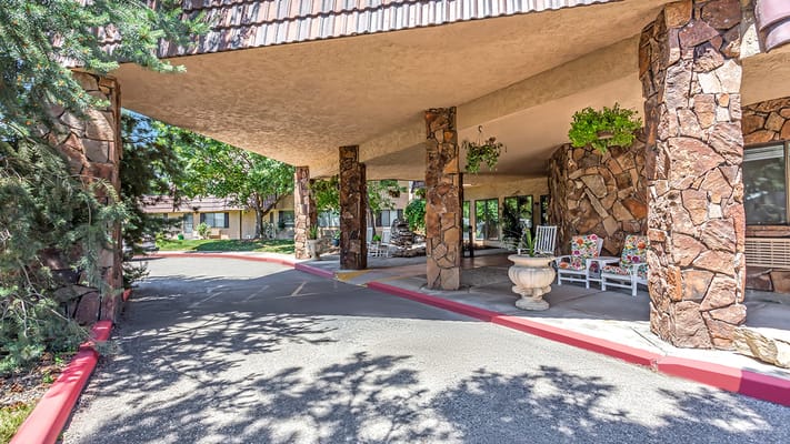 Covered entrance with stone columns and greenery
