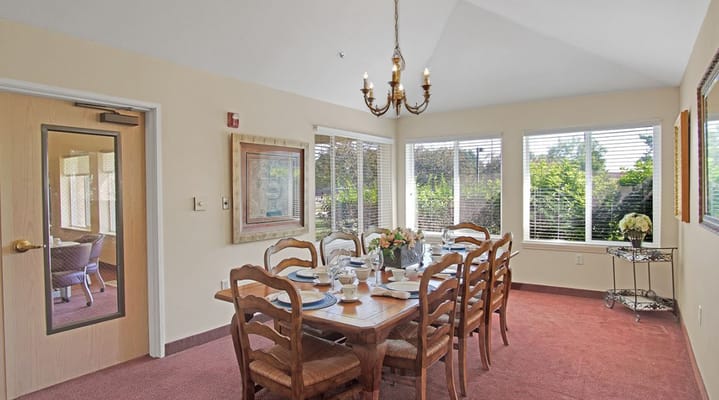 Cozy dining room with a large wooden table and windows
