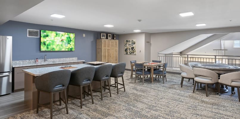 A spacious common area with seating and a kitchen counter