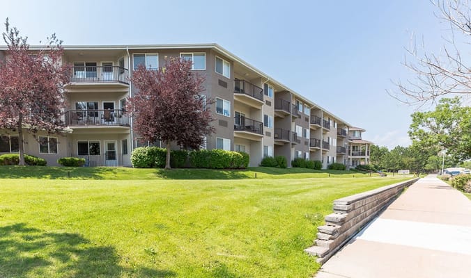 Exterior view of a senior living facility with greenery