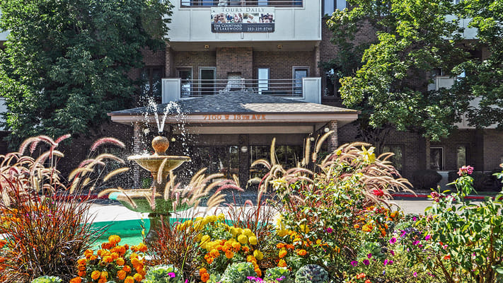 Fountain surrounded by colorful flowers at the entrance of The Courtyard At Lakewood.
