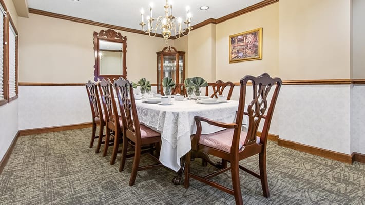 A dining room setup with a large table and chandelier