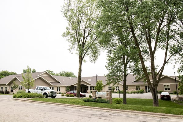 Exterior view of Home Again Assisted Living with trees