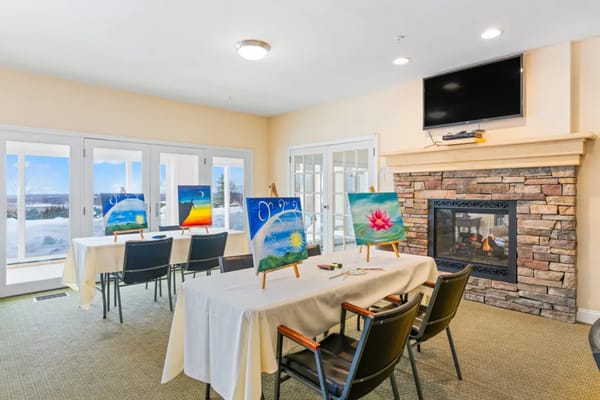 Art class setup in a bright activity room with paintings